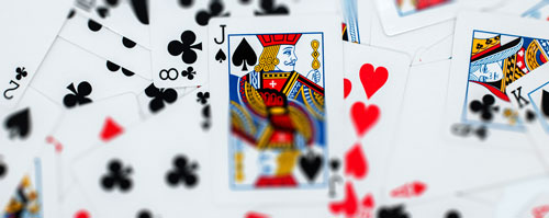 Playing cards piled, Jack of Spades showing.